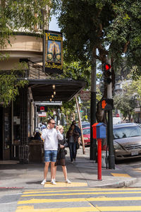 Rear view of people walking on street in city