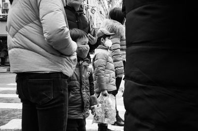 Rear view of people standing on street