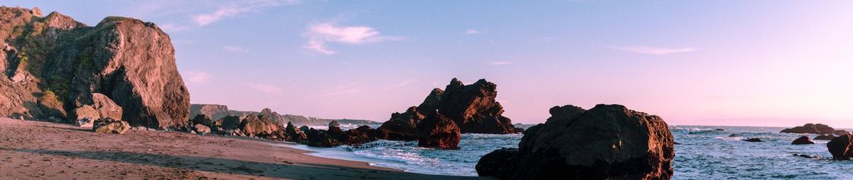 Panoramic view of rocks on beach against sky