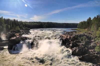 Scenic view of waterfall against sky