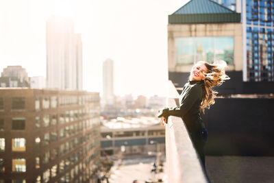 Portrait of young woman with cityscape in background