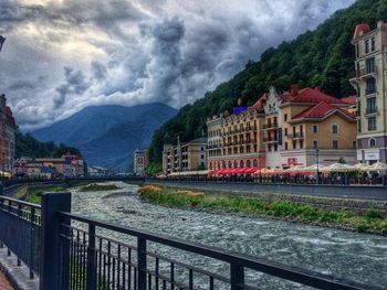 View of canal and buildings against cloudy sky