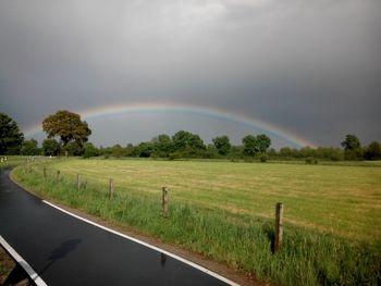 Country road against cloudy sky