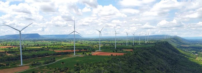 Windmills on field against sky