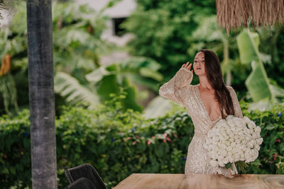 Young girl in a golden dress with a bouquet of white roses