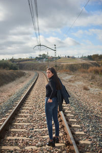 Rear view of woman walking on railroad track