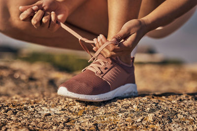 Low section of woman tying shoelace