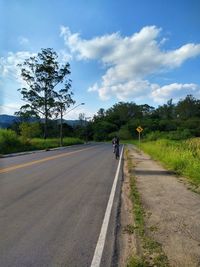 Road amidst trees against sky