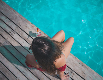 High angle view of woman sitting at poolside