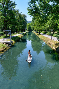 Woman on boat in lake against trees