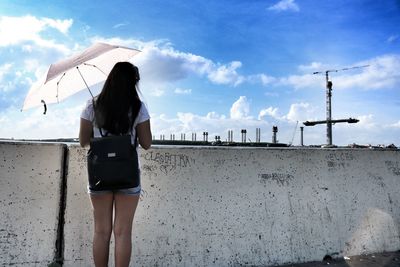 Rear view of woman standing against sky