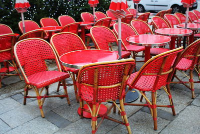 Empty chairs and tables at sidewalk cafe