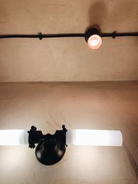 Low angle view of light bulb hanging on ceiling
