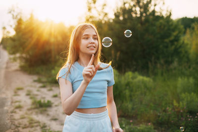 Cute girl making bubble outdoors