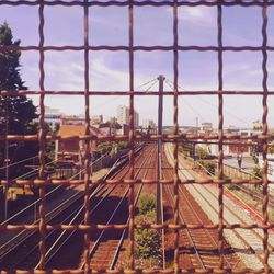 Railroad tracks in city against sky