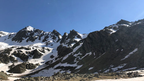 Scenic view of snowcapped mountains against clear blue sky