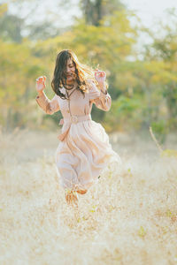 Close-up of young woman with umbrella on field