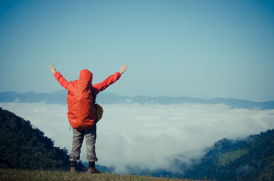 Full length of man standing on mountain against blue sky