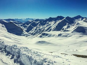 Scenic view of snowcapped mountains against clear blue sky