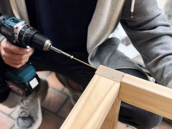 Midsection of man working on wood