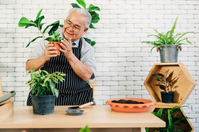 Midsection of man holding potted plant