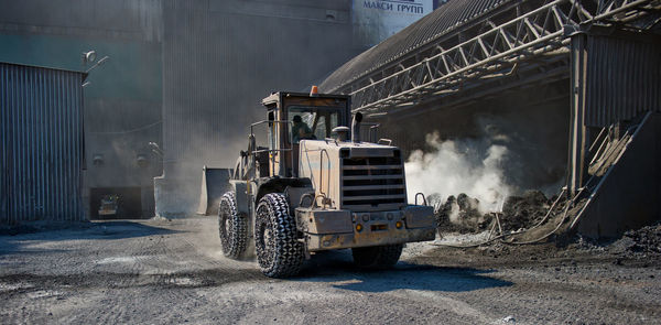 Bulldozer at steel factory during sunny day