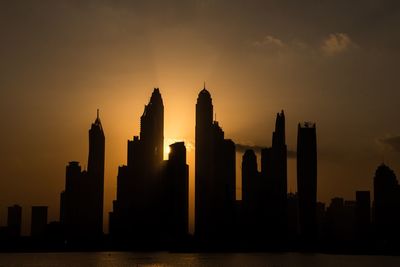 Silhouette of buildings against sky during sunset