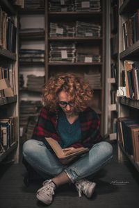 Portrait of young woman sitting on book
