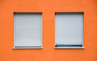 Full frame shot of orange wall with windows