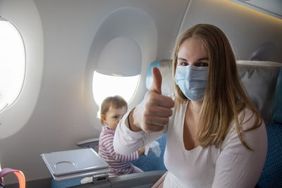 Portrait of mother wearing mask with daughter at airplane