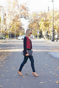 Rear view of woman walking on road