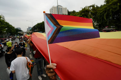 People holding multi colored umbrella in city
