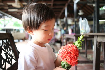 Cute girl holding red flower bouquet