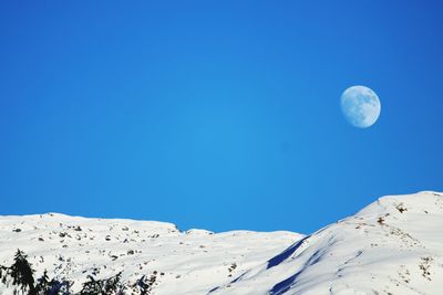 Scenic view of snowcapped mountains against blue sky