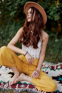 Young woman looking away while sitting at park