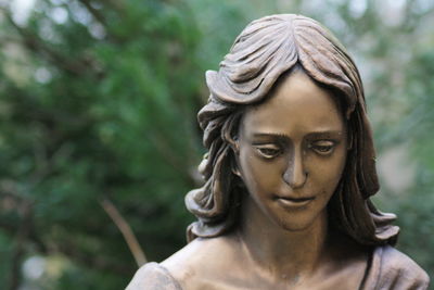 Close-up of young woman against tree