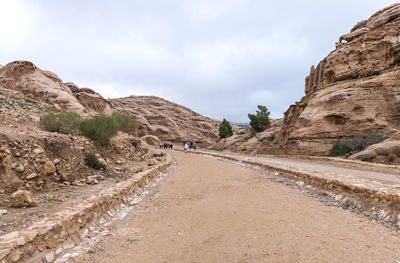 Road leading towards mountains against sky