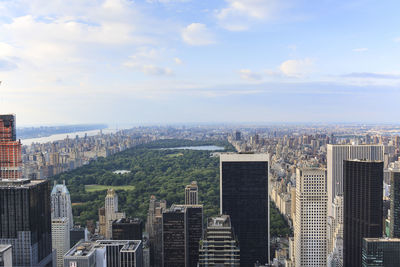 Aerial view of cityscape against cloudy sky