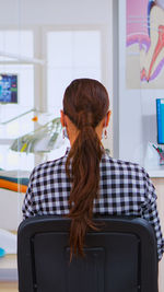 Side view of woman using laptop at home