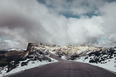 Road amidst snowcapped mountains against sky