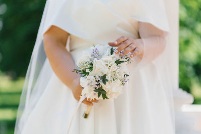 Delicate wedding bouquet with white hydrangea in the hands of the bride