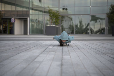 Girl skateboarding on footpath