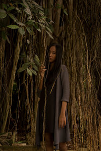 Young woman standing amidst plants