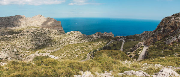 Scenic view of sea by cliff against sky