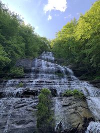 Scenic view of waterfall in forest against sky