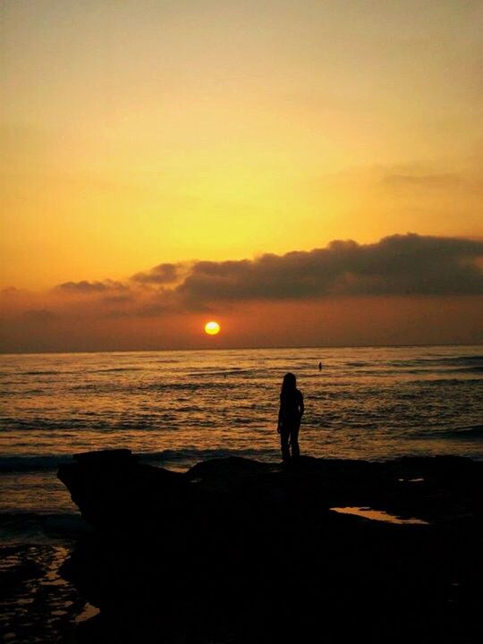 sunset, silhouette, sea, water, horizon over water, scenics, sky, tranquil scene, beauty in nature, tranquility, orange color, beach, sun, idyllic, nature, shore, standing, cloud - sky