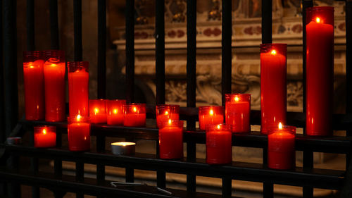 Illuminated tea light candles in temple against building