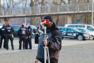 Man holding umbrella on street in city