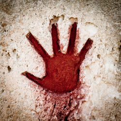 Close-up of human hand on red wall