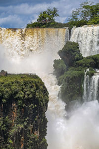 Scenic view of waterfall against sky